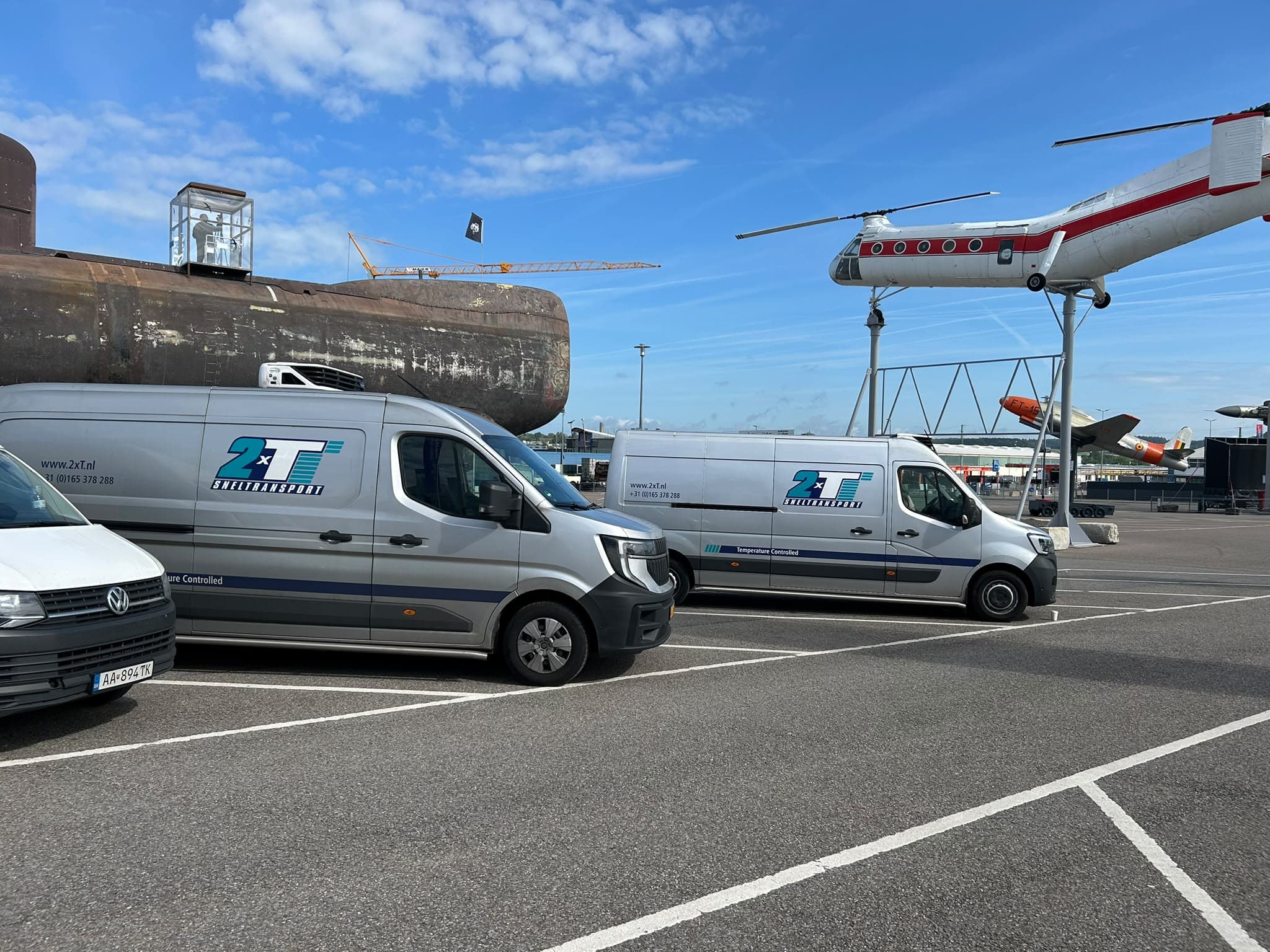 Twee gekoelde Renault Masters van 2xT Sneltransport bij een luchthaven